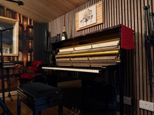 Yamaha pianos in a recording studio setting, featuring wooden paneling and decorative elements.